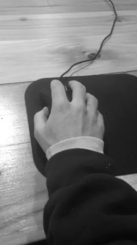 A hand moving a mouse around a mouse pad.
